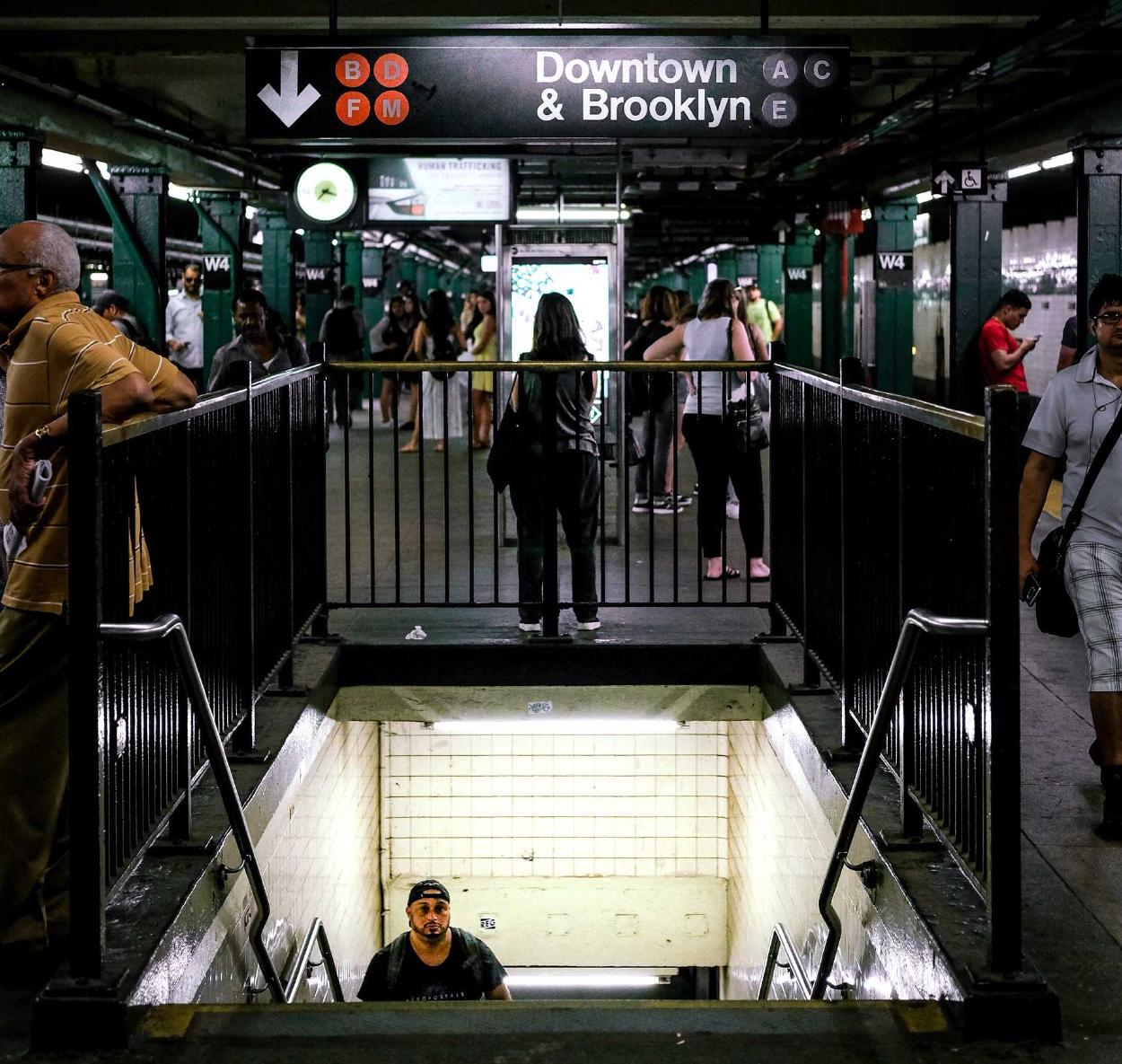 A man walks up stairs at the Brooklyn Downtown subway station.